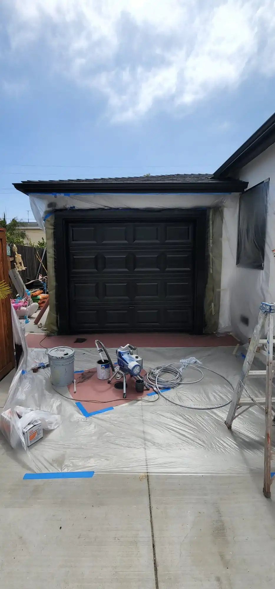 Exterior home painting project with sprayer and ladder in Brooklyn NY