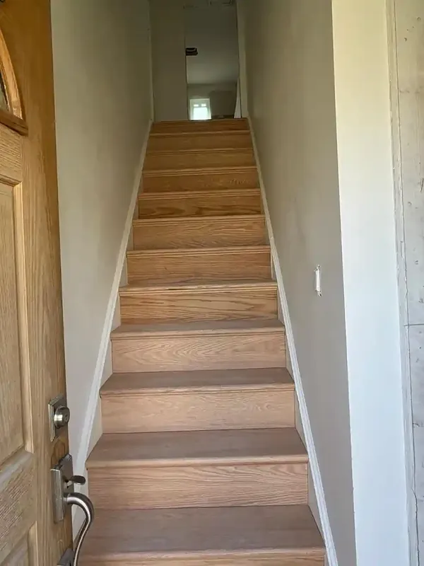 Finished interior staircase with oak treads and white walls in Brooklyn home