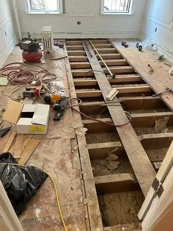 Interior subfloor replacement exposing floor joists during renovation