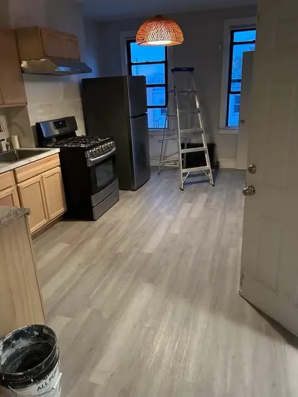Kitchen renovation with wood cabinets, black appliances and new vinyl floor