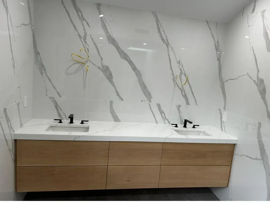 Modern bathroom double vanity with marble-look tile and floating wood cabinet