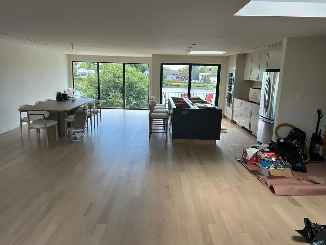 Open concept kitchen and dining room renovation with wood floors and lake view