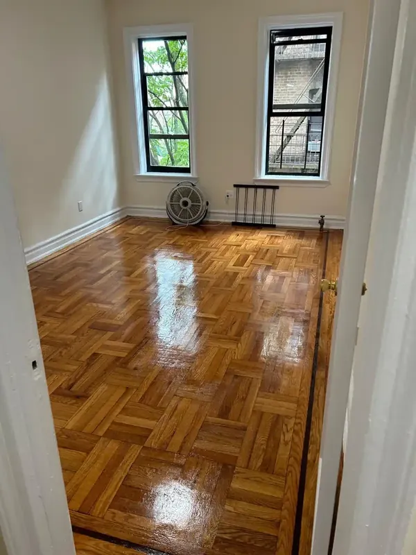 Renovated room with refinished parquet wood floor and white walls
