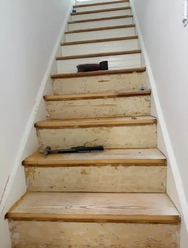 Staircase refinishing in progress with wood treads and white risers